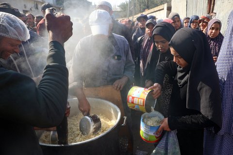 Des Palestiniens se rassemblent pour recevoir de l'aide alimentaire distribuée à Deir al-Balah, dans le centre de la bande de Gaza, le 16 janvier 2025, après l'annonce d'une trêve au milieu de la guerre en cours entre Israël et le Hamas.