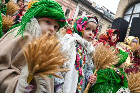 Des enfants en costumes folkloriques tiennent des gerbes de blé lors de l'inauguration d'un didukh de quatre mètres, une décoration de Noël ukrainienne faite d'une gerbe de blé, sur la place Anheliv avant Noël à Lviv, en Ukraine, le 24 décembre 2024.